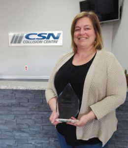 mandie steen from champlain auto body holding expansion dieppe busines service excellence award