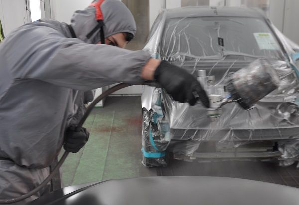 Spray painting a hood with the matching color.